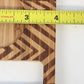 Wooden cutting board with a chevron pattern measured by a Stanley ruler.