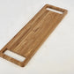 Bamboo cutting board with handles on a white surface
