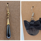 Two pairs of vintage black dangle earrings with gold and silver tone designs