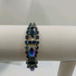 Vintage 1960s Blue Rhinestone Bracelet – Silver Tone Metal with Faceted Oval & Round Stones – Black Enamel & Leaf Detail – 7" Open Box Clasp