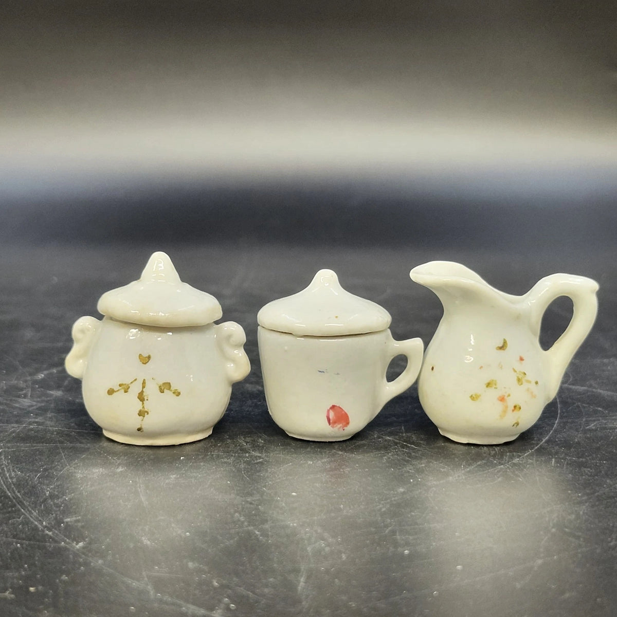 Mini cream porcelain tea set with floral details, creamer, sugar bowl and cup