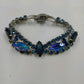 Vintage 1960s Blue Rhinestone Bracelet – Silver Tone Metal with Faceted Oval & Round Stones – Black Enamel & Leaf Detail – 7" Open Box Clasp