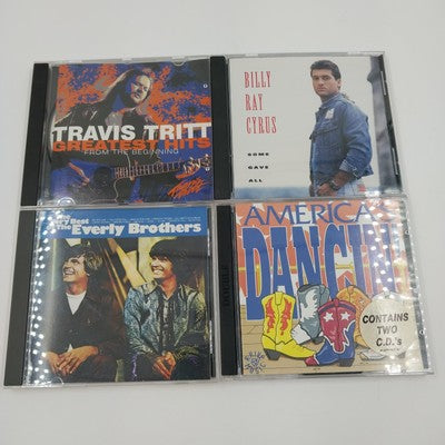 Four country music CDs featuring Travis Tritt and Billy Ray Cyrus