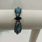 Vintage 1960s Blue Rhinestone Bracelet – Silver Tone Metal with Faceted Oval & Round Stones – Black Enamel & Leaf Detail – 7" Open Box Clasp