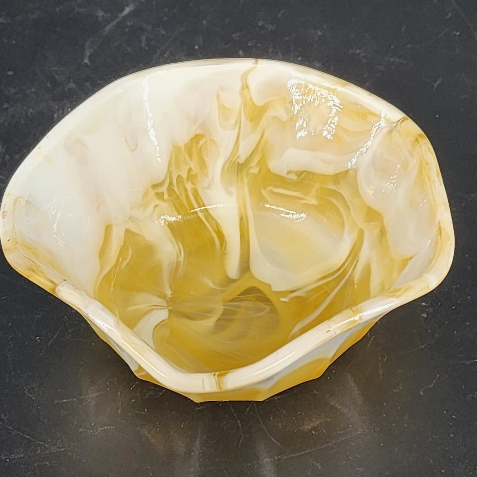 Caramel slag glass bowl with scalloped rim and yellow white swirl design