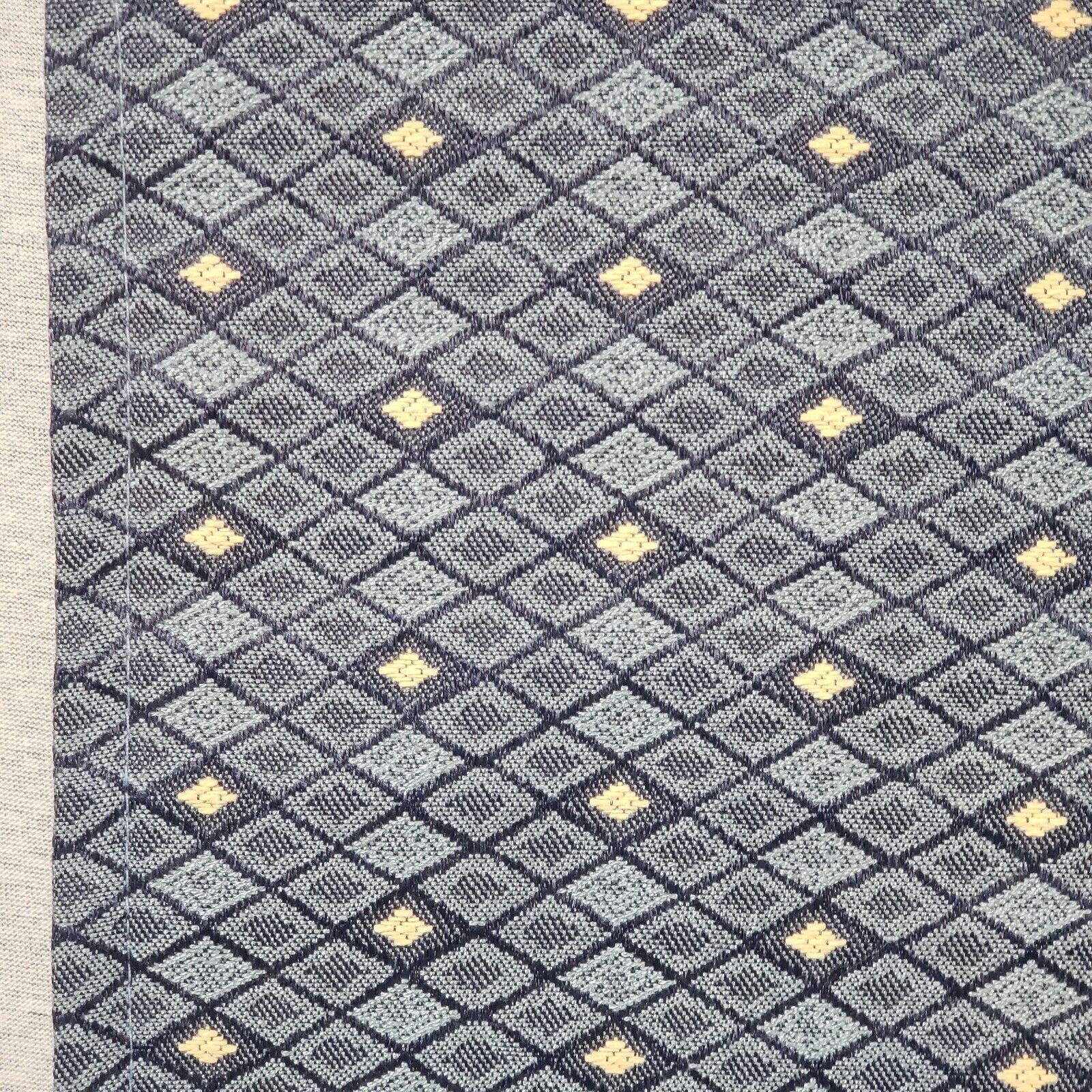 Long blue upholstered table runner with tan geometric cell pattern