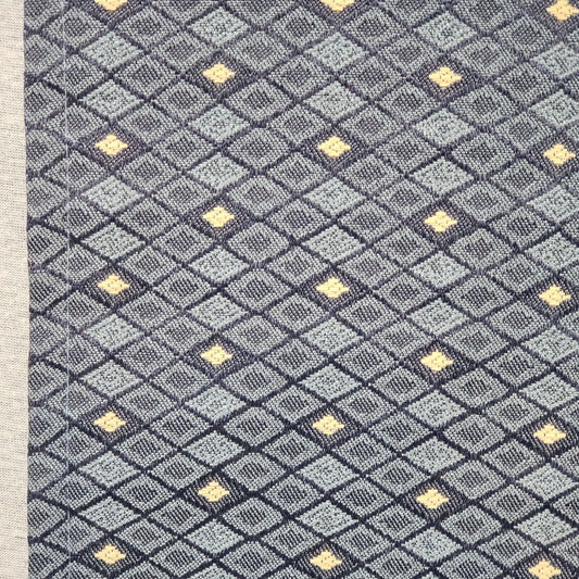 Long blue upholstered table runner with tan geometric cell pattern