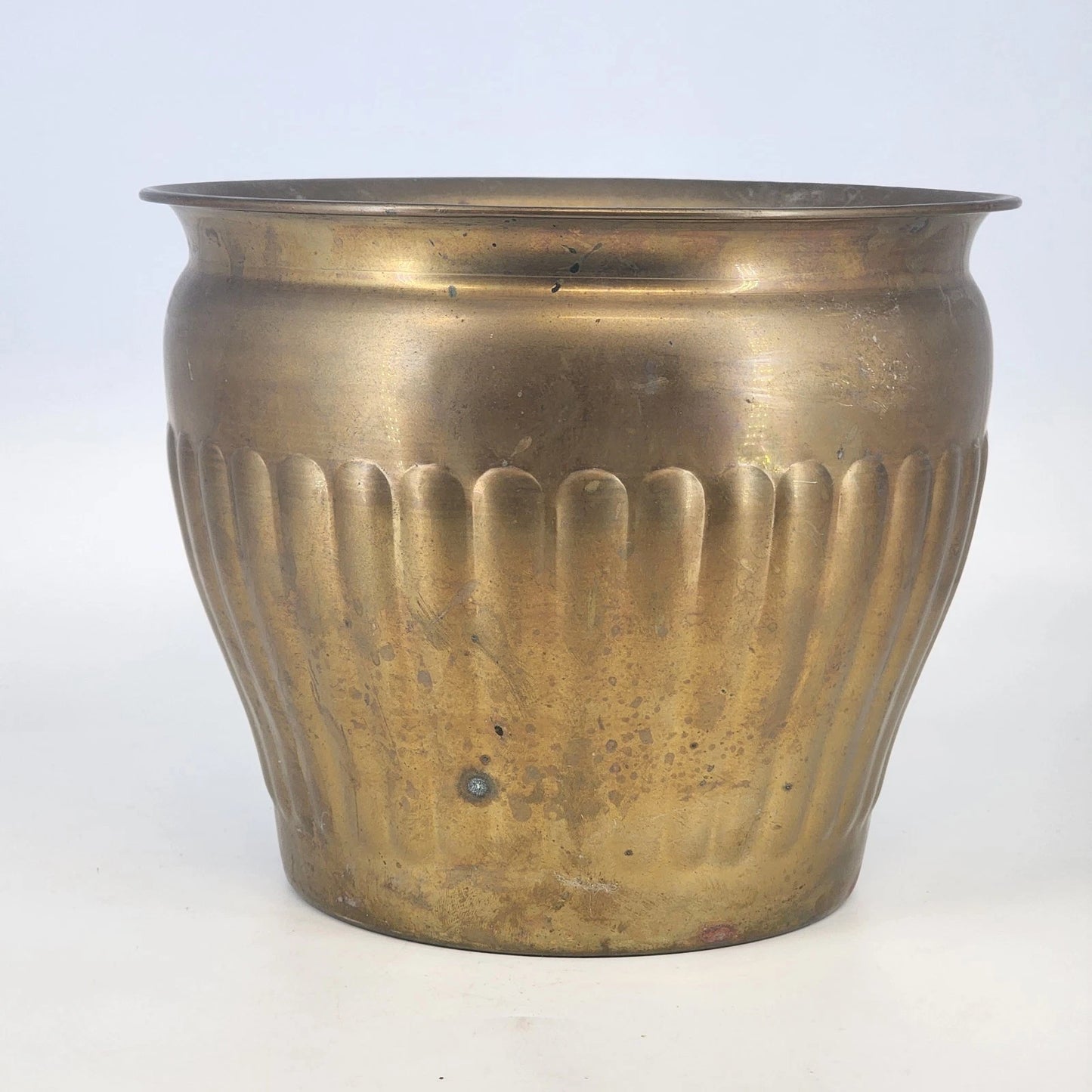 Bronze pot with ribbed design on a white background