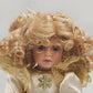 13 inch porcelain doll with blonde curly hair and display stand