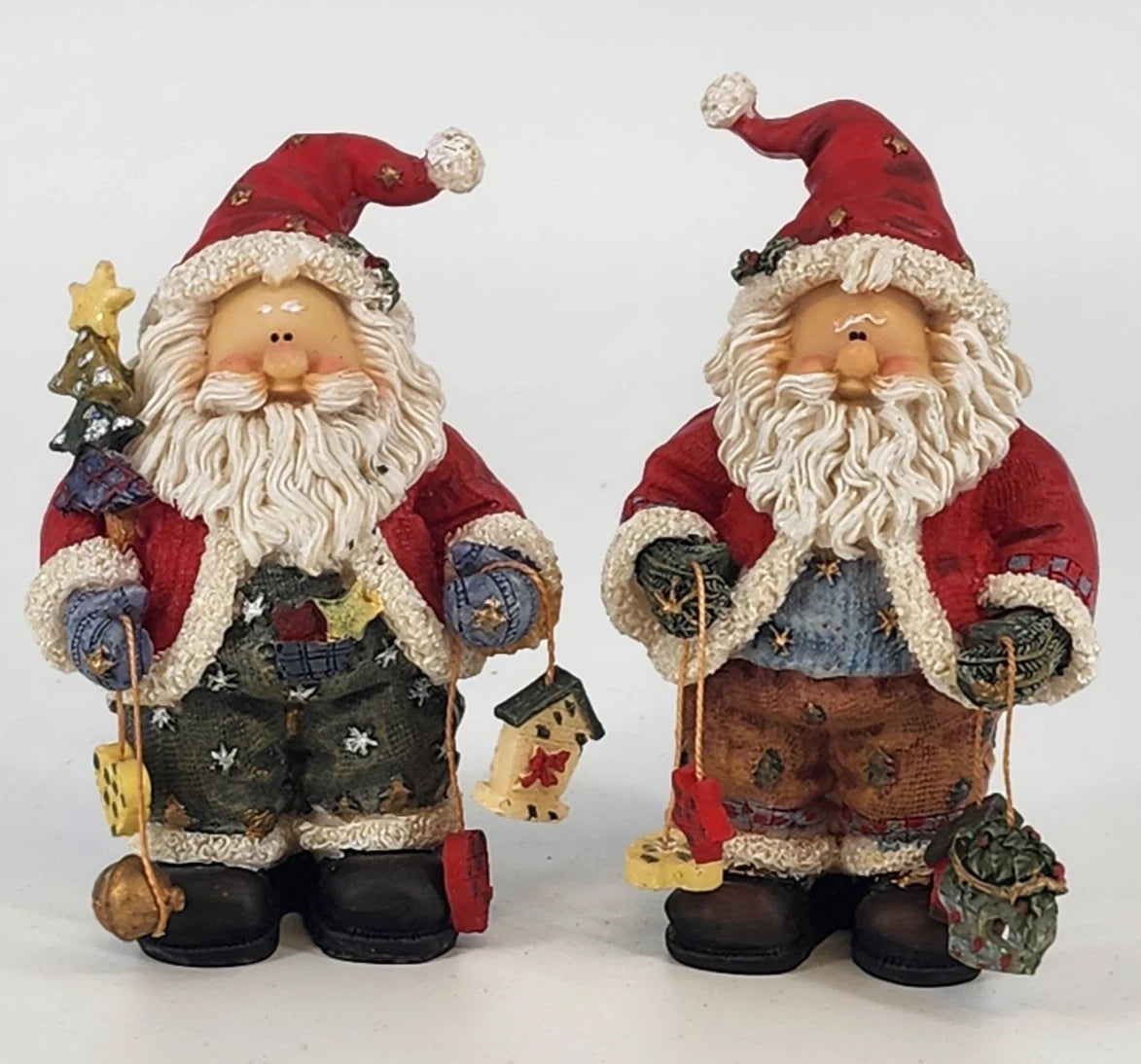 Set of vintage resin Santa figurines holding birdhouse and Christmas tree