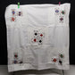 White embroidered card table cover with playing card designs