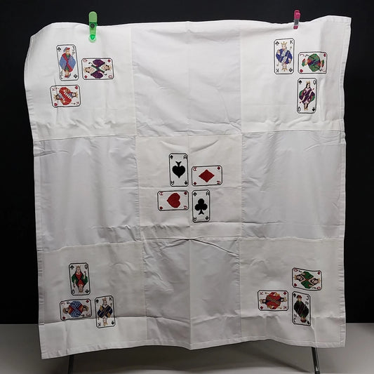 White embroidered card table cover with playing card designs