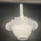 White textured vase with a handle on a dark background