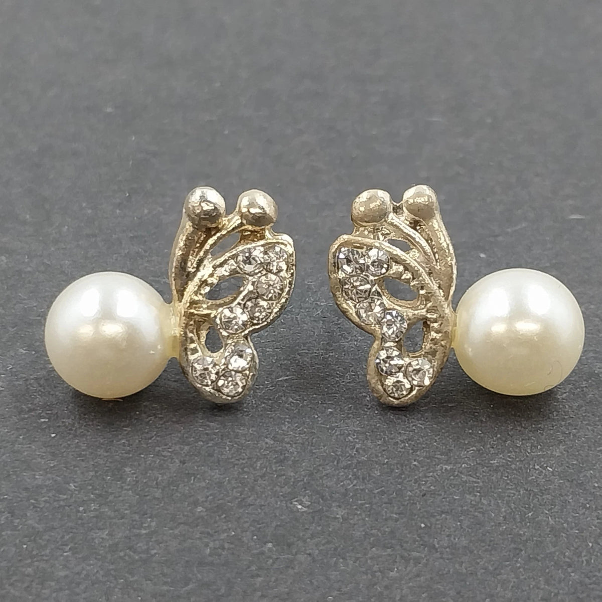 Gold tone butterfly wing stud earrings with faux pearls and clear rhinestones