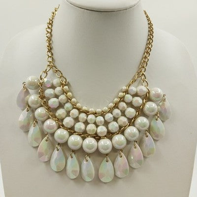 Gold tone bib necklace with white faceted round and teardrop beads