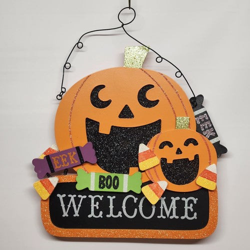 Orange and black pumpkin shaped Halloween welcome sign with glitter candy accents