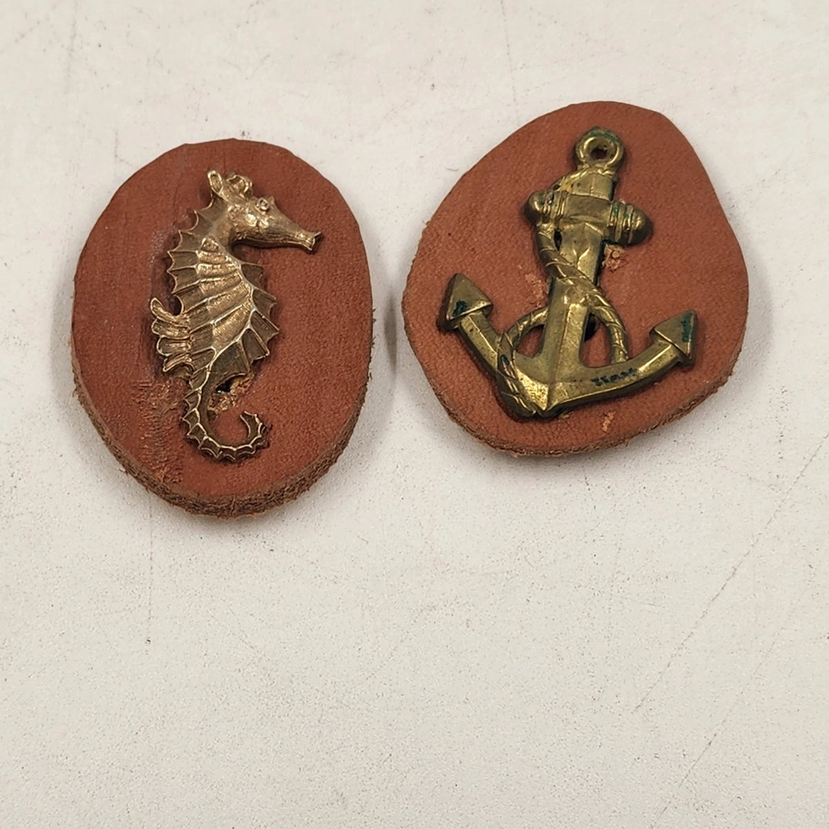 Vintage handmade brass and leather scout pins with seahorse and anchor