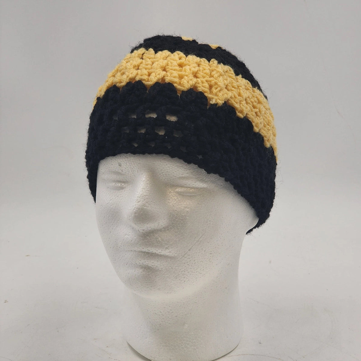 Handmade crochet messy bun beanie with black yellow striped design