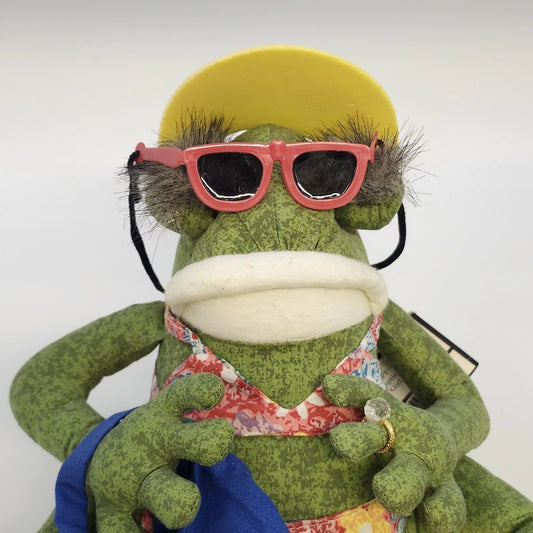 JoAnn Marie Designs California Girl frog doll, SKU FF-4, wearing a colorful floral beach outfit, yellow visor, red sunglasses, blue beach bag, and brown sandals.