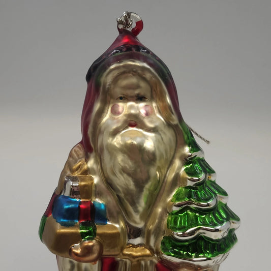 Large blown glass Santa Claus Christmas ornament in a red robe holding a green tree and colorful wrapped gifts
