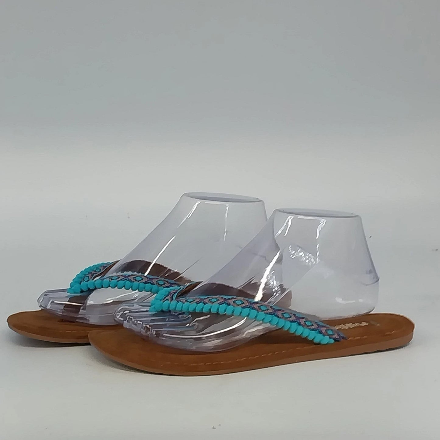 Mad Love brown thong sandals with turquoise pom pom accents