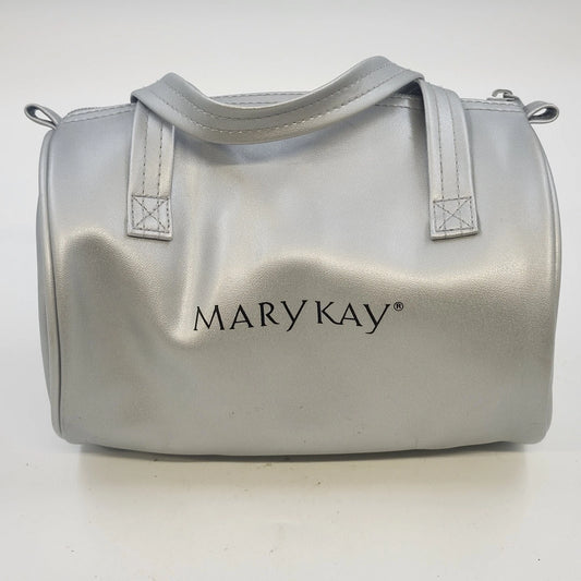 Mary Kay silver metallic barrel cosmetic bag with dual handles and zipper closure.