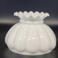 White glass lamp shade with ruffled top on a dark background