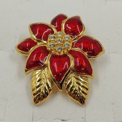 Monet red poinsettia brooch with gold tone finish and clear rhinestones