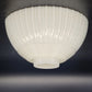 White ribbed ceiling light fixture on a dark background