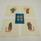 Set of four completed desert plant cross stitch designs on white Aida cloth