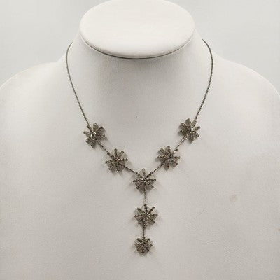 Silver tone necklace with rhinestone starburst flower pendant