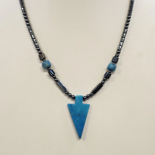 Black beaded necklace with blue arrowhead pendant and metallic accents