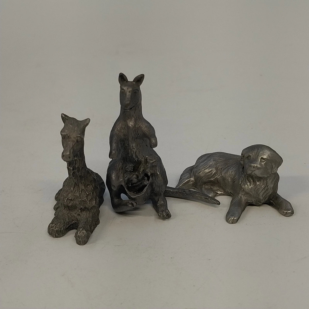 Three pewter animal figurines kangaroo giraffe and reclining dog