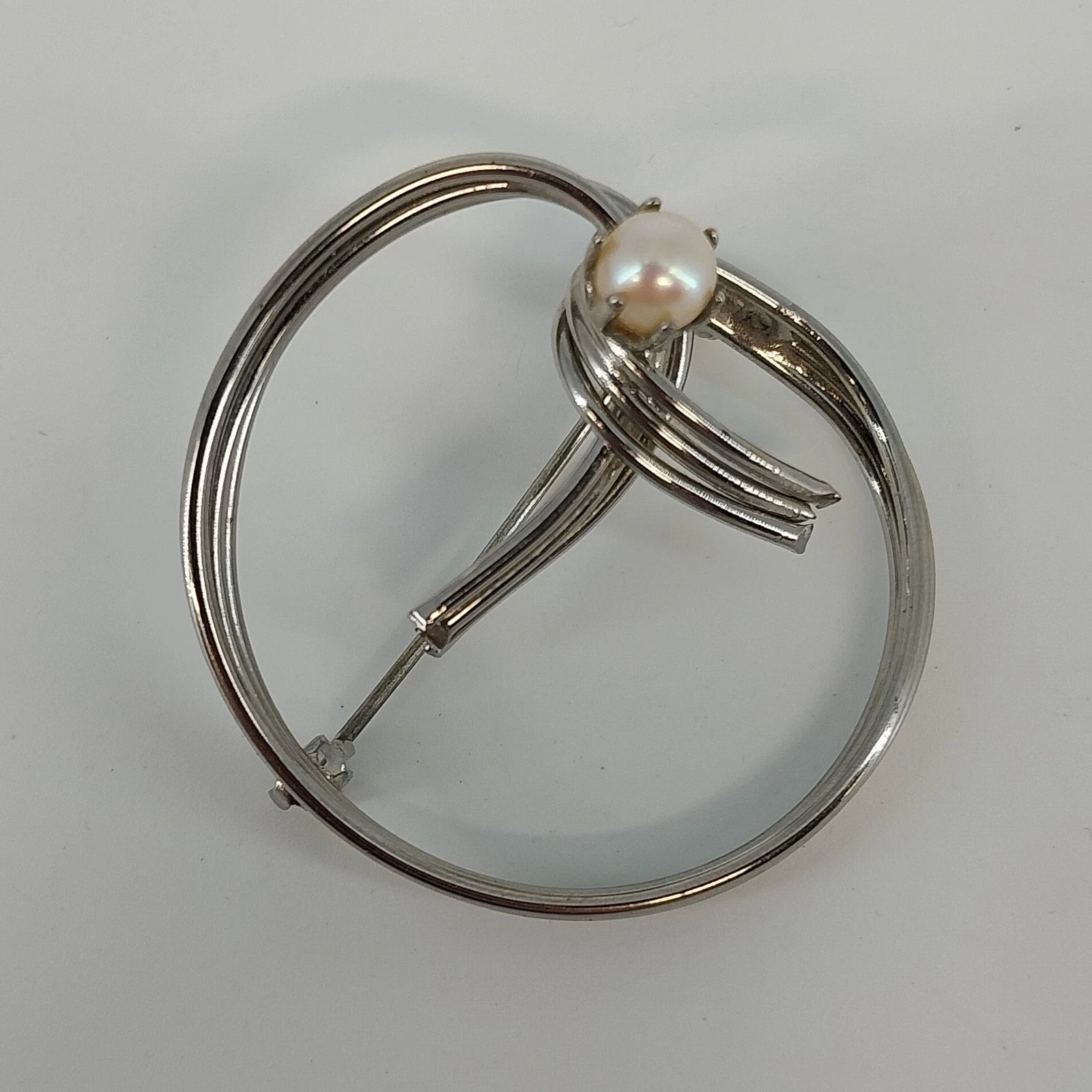 Sterling silver circle brooch with faux pearl center and polished finish