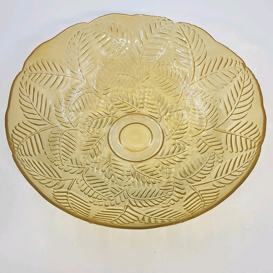 Vintage transparent amber glass bowl with raised leaf pattern and scalloped rim.