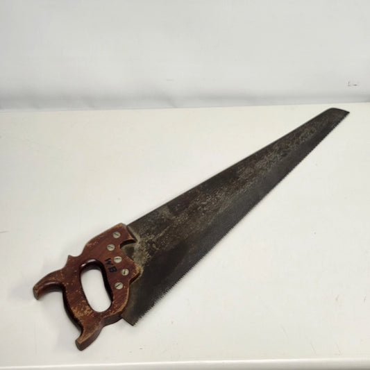 Vintage 26-inch crosscut hand saw with carved reddish-brown wood handle and aged steel blade.