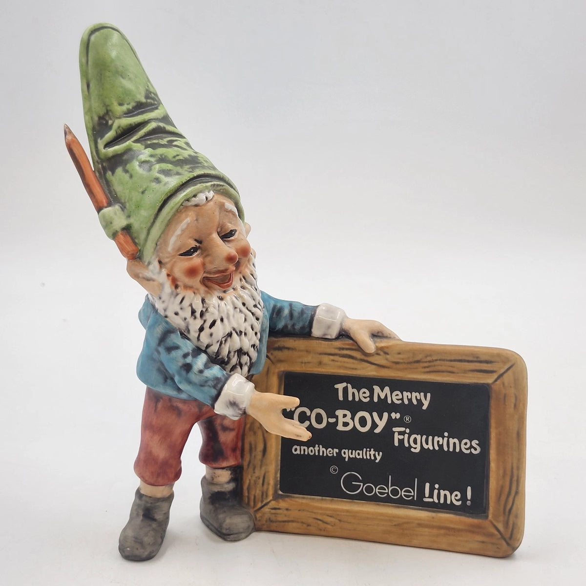 Goebel Co-Boy gnome figurine with green hat and advertising sign