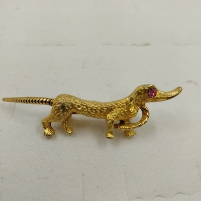 Vintage gold tone dachshund dog brooch with pink rhinestone eye