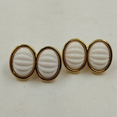 Gold tone clip-on earrings with white ribbed oval stones and stacked design