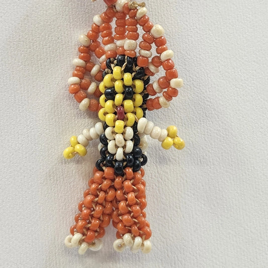 Colorful handmade beaded necklace with a human-like figure pendant and Hong Kong paper label.