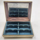 Vintage square ivory jewelry case with gold-tone trim, hinged mirror lid, and blue velvet divided interior for rings and earrings.