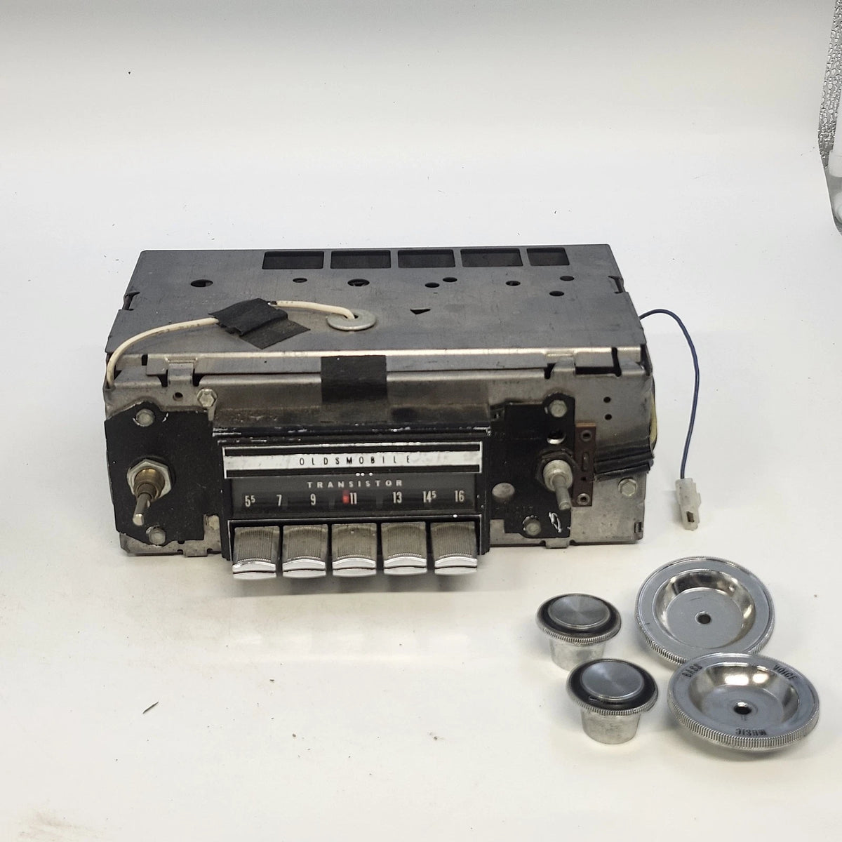 Vintage Oldsmobile Delco AM car radio with chrome buttons and knobs