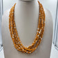 Layered 24-inch necklace with irregular orange and white chip-style beads and gold-tone end caps.
