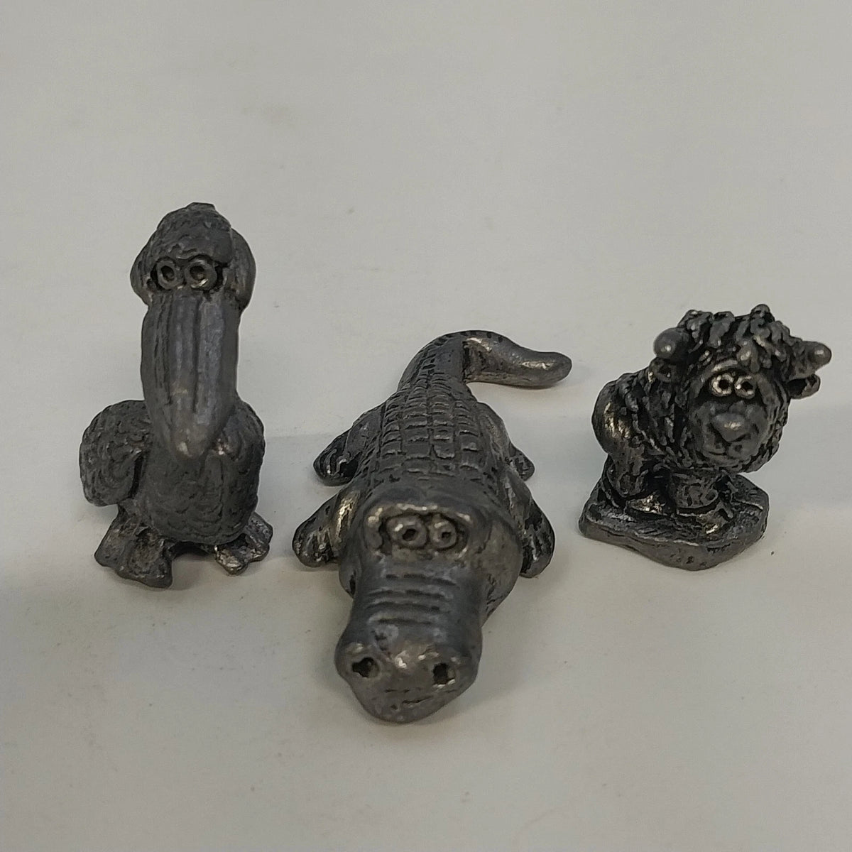 Three vintage pewter animal figurines pelican alligator creature