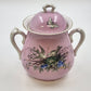Vintage pink porcelain biscuit jar with birds, flowers, butterfly, and gold trim