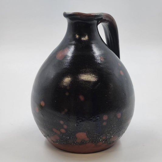 Small redware pottery pitcher with dark mottled brown glaze