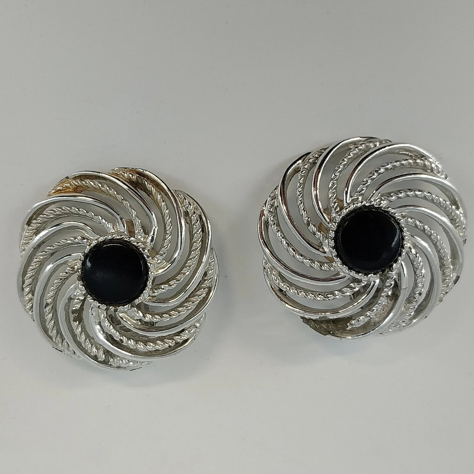 Vintage Sarah Coventry Mystic Swirl clip on earrings with black cabochons and silver tone swirl design