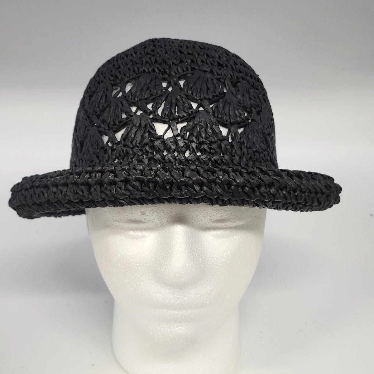 Black woven cloche hat with floral openwork and rolled brim