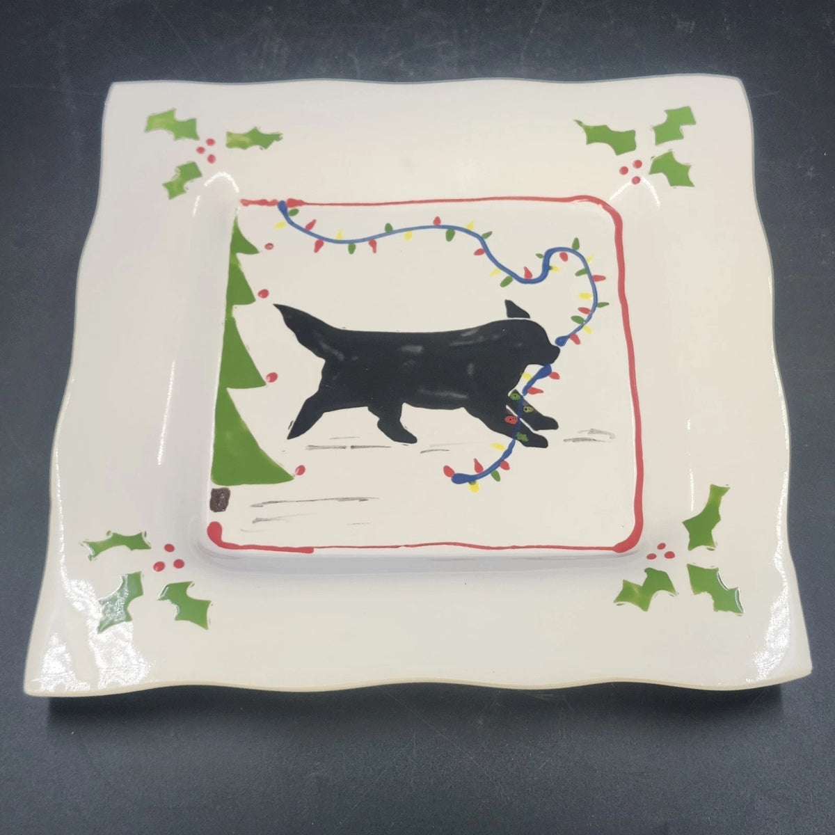Vintage ceramic platter with black dog pulling a red and green Christmas sled