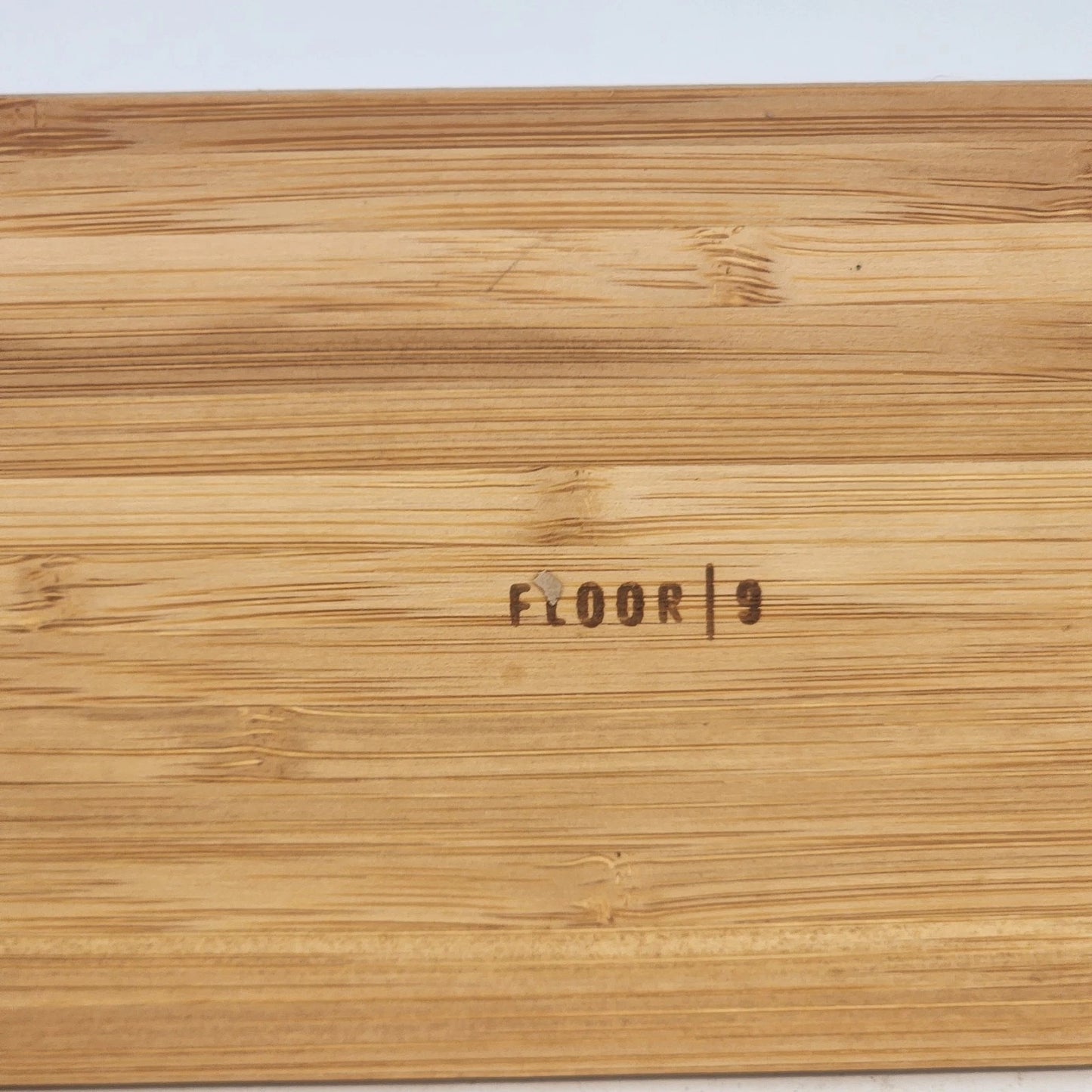 Wooden floor sample with 'FLOOR 9' branding on a light gray background